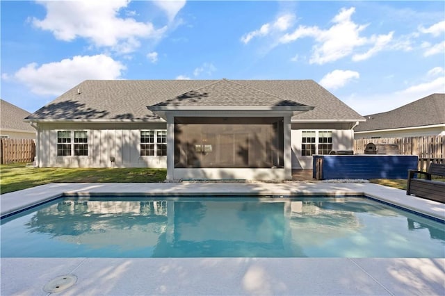 view of swimming pool featuring a sunroom and a lawn