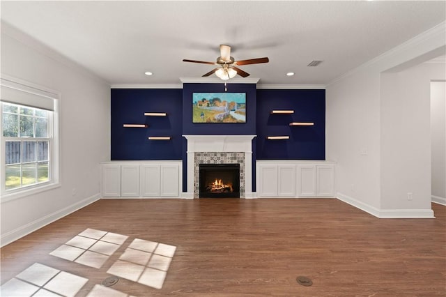 unfurnished living room with a fireplace, hardwood / wood-style floors, ceiling fan, and crown molding