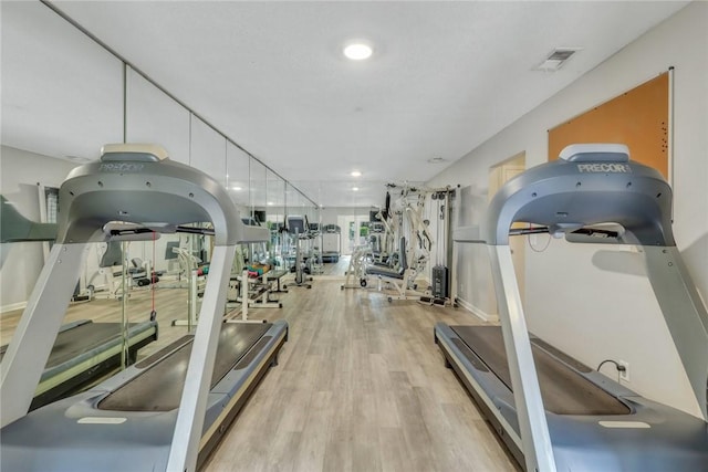 exercise room with wood finished floors and visible vents