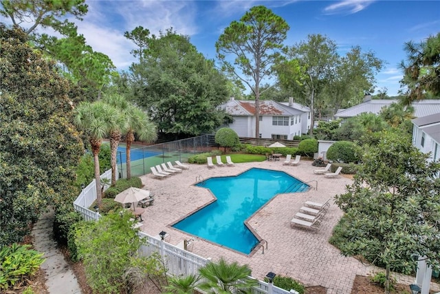 community pool featuring a fenced backyard and a patio