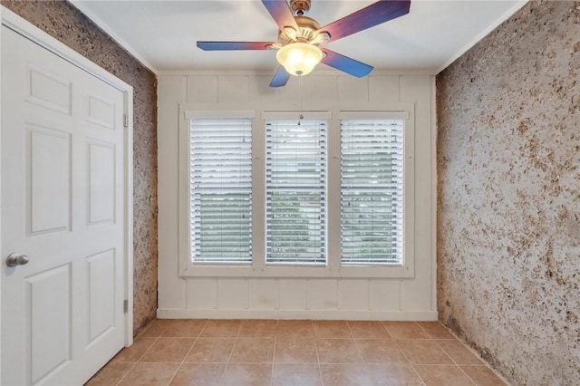 unfurnished room with light tile patterned floors, ceiling fan, and ornamental molding