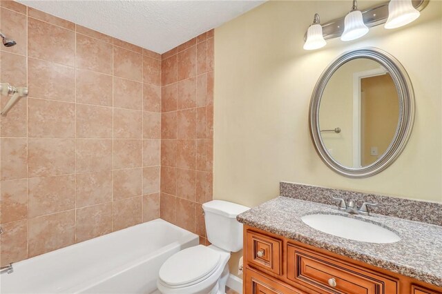 bathroom with a textured ceiling, toilet, shower / bath combination, and vanity