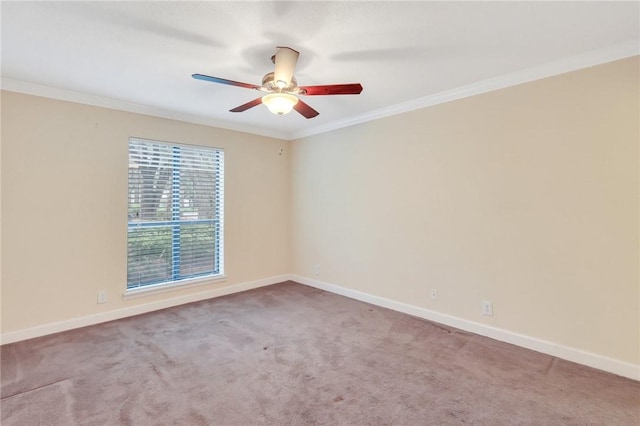 spare room featuring a ceiling fan, carpet, crown molding, and baseboards