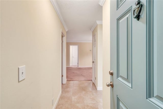 corridor with light tile patterned floors, baseboards, ornamental molding, and a textured ceiling