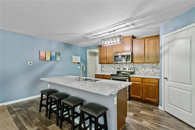 310 Brooklet Cir, Saint Marys, GA 31558 - kitchen featuring stainless steel appliances, a sink, brown cabinetry, dark wood-type flooring, and a textured ceiling