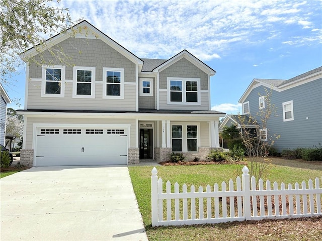 craftsman-style house featuring brick siding, an attached garage, fence, a front yard, and driveway