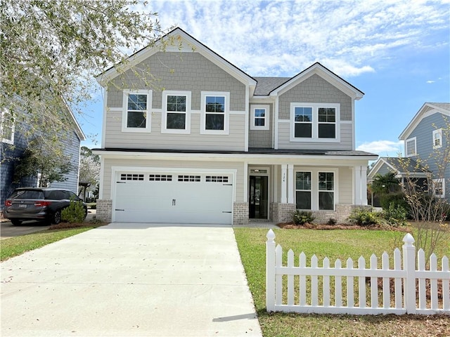 craftsman-style home with brick siding, driveway, a front yard, and fence