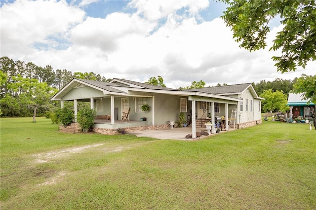 back of property with a lawn and covered porch