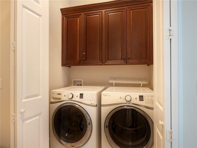 laundry area featuring separate washer and dryer and cabinets