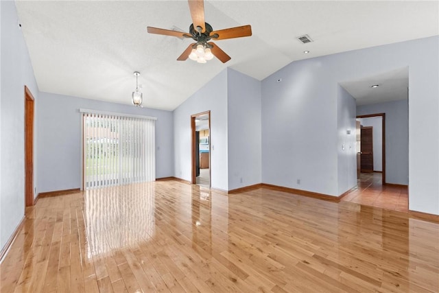 empty room with ceiling fan, vaulted ceiling, and light hardwood / wood-style flooring