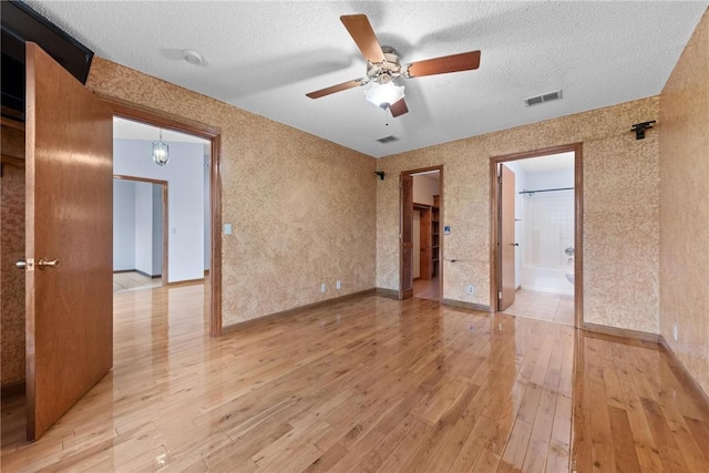 empty room featuring hardwood / wood-style floors, ceiling fan, and a textured ceiling