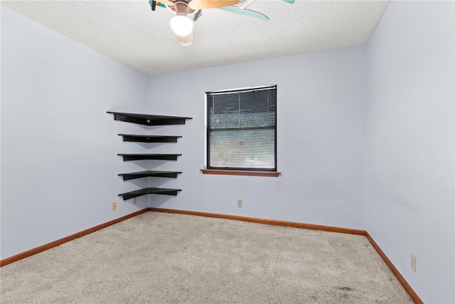 empty room with carpet flooring, ceiling fan, and a textured ceiling