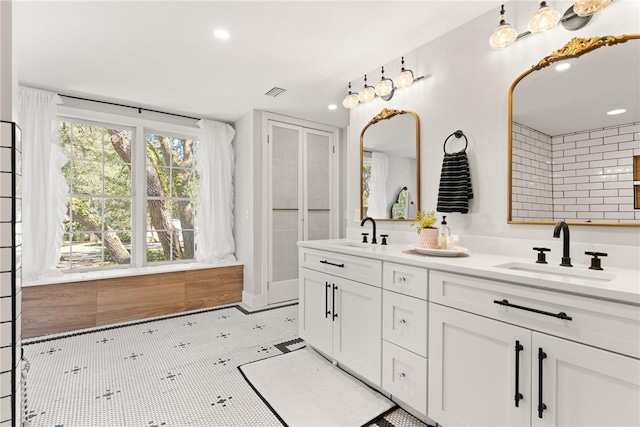 full bathroom featuring double vanity, visible vents, recessed lighting, and a sink