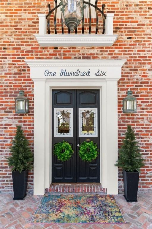 property entrance with brick siding and french doors