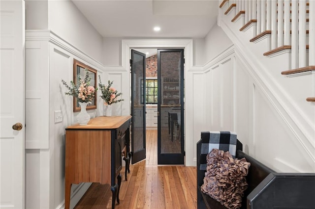 interior space featuring recessed lighting, light wood-type flooring, stairway, and a decorative wall