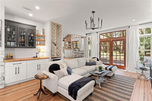 living area with recessed lighting, visible vents, a chandelier, and light wood finished floors