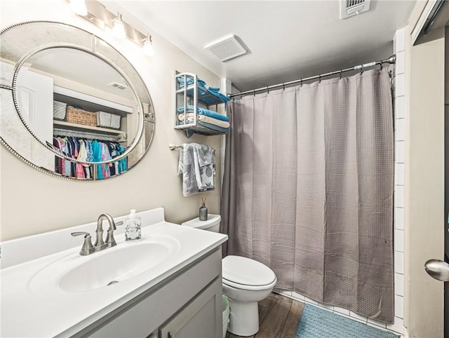 1524 Wood Ave Unit 106, Saint Simons Island, GA 31522 - bathroom featuring vanity, toilet, wood finished floors, and visible vents
