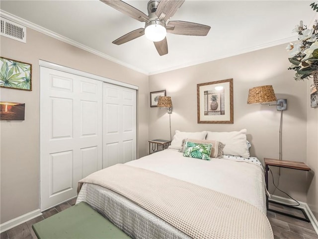 1524 Wood Ave Unit 106, Saint Simons Island, GA 31522 - bedroom with visible vents, crown molding, dark wood finished floors, baseboards, and a closet