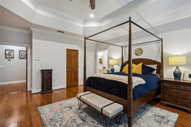 bedroom featuring dark hardwood / wood-style flooring, ceiling fan, and ornamental molding