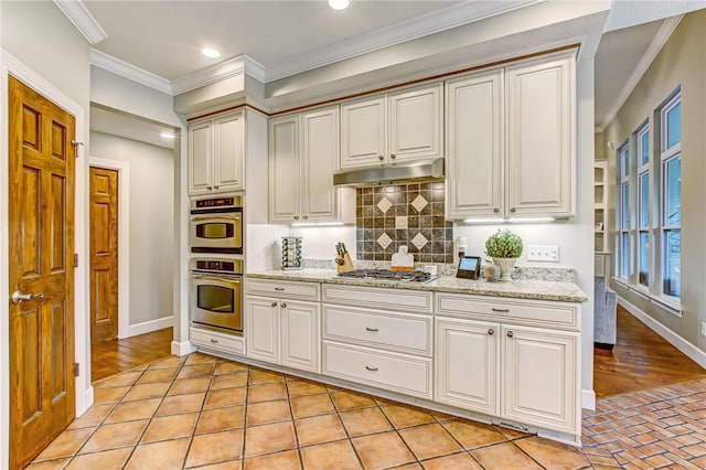 kitchen with backsplash, light stone countertops, ornamental molding, light wood-type flooring, and stainless steel appliances