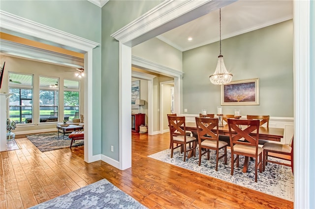 dining room featuring ceiling fan with notable chandelier, hardwood / wood-style flooring, and crown molding