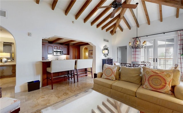 living room featuring beamed ceiling, ceiling fan with notable chandelier, high vaulted ceiling, and french doors