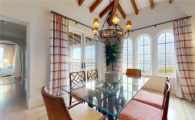 tiled dining room with vaulted ceiling with beams, a wealth of natural light, french doors, and a chandelier