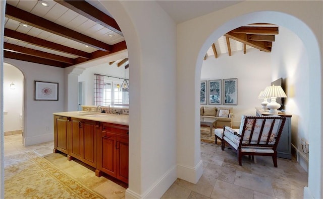 corridor featuring beamed ceiling, wooden ceiling, and sink