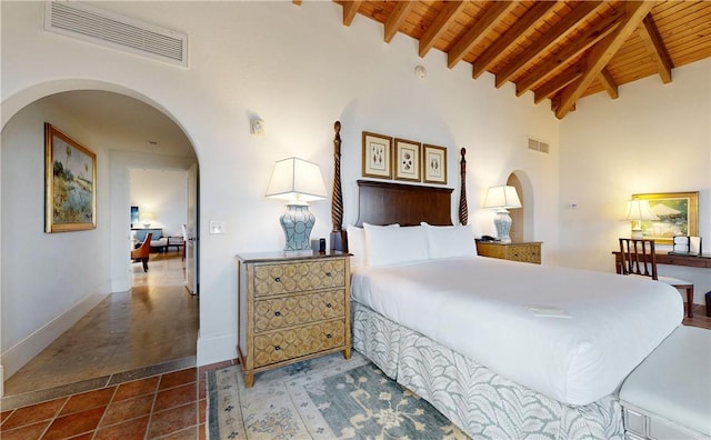 bedroom featuring beamed ceiling, high vaulted ceiling, dark tile patterned floors, and wooden ceiling