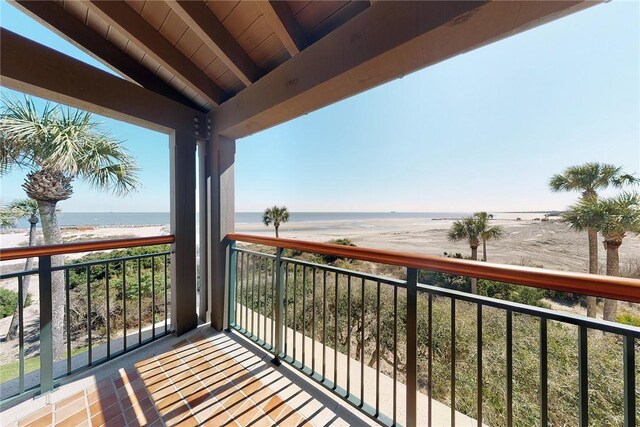 balcony featuring a water view and a beach view