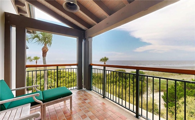 balcony featuring a view of the beach and a water view