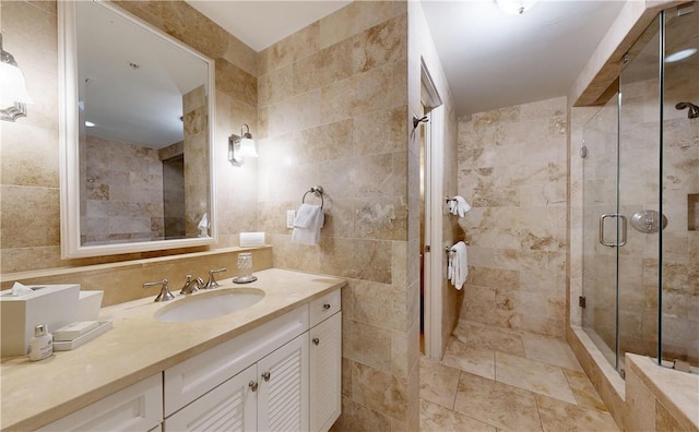 bathroom featuring an enclosed shower, vanity, and tile walls