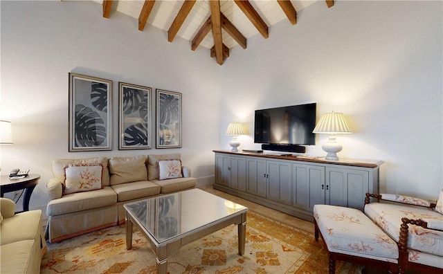 living room featuring lofted ceiling with beams and light hardwood / wood-style flooring