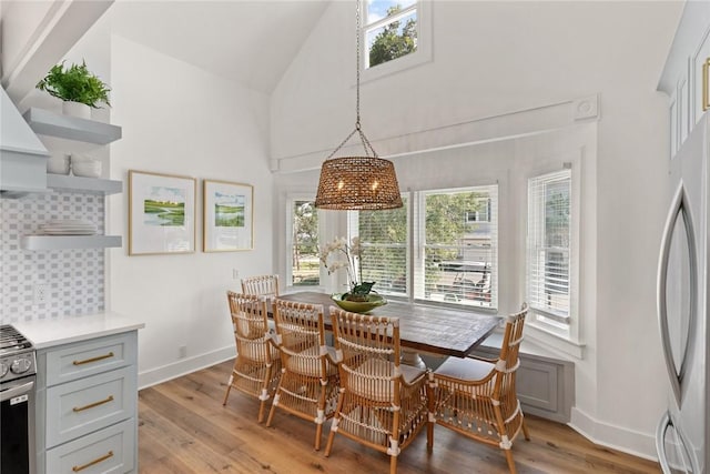 108 Hamilton St, Saint Simons Island, GA 31522 - dining room featuring light wood finished floors, high vaulted ceiling, and a chandelier