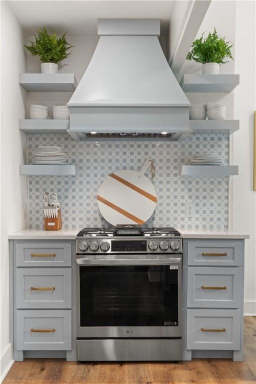 108 Hamilton St, Saint Simons Island, GA 31522 - kitchen with stainless steel gas stove, open shelves, custom range hood, and gray cabinetry