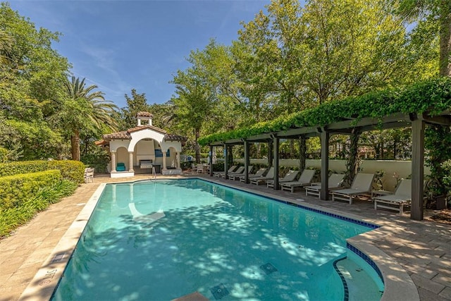 view of swimming pool featuring a patio area and an outdoor fireplace