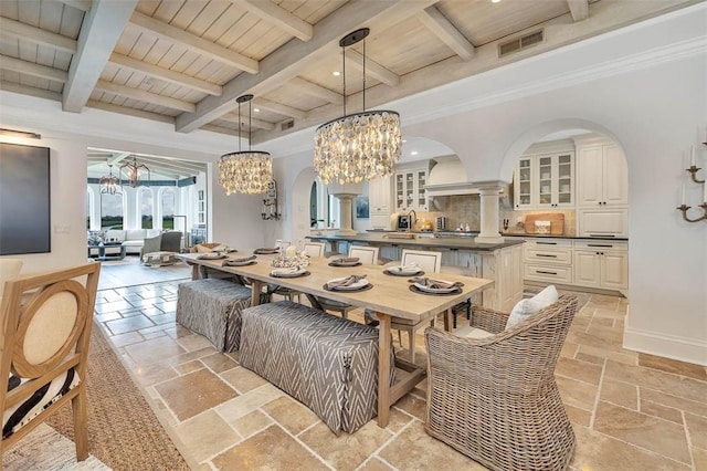 dining room featuring beamed ceiling, wood ceiling, ornamental molding, and a chandelier