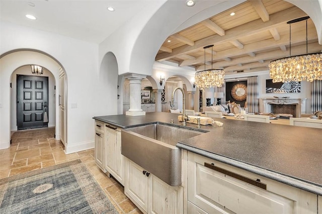 kitchen with pendant lighting, wooden ceiling, an inviting chandelier, sink, and beamed ceiling