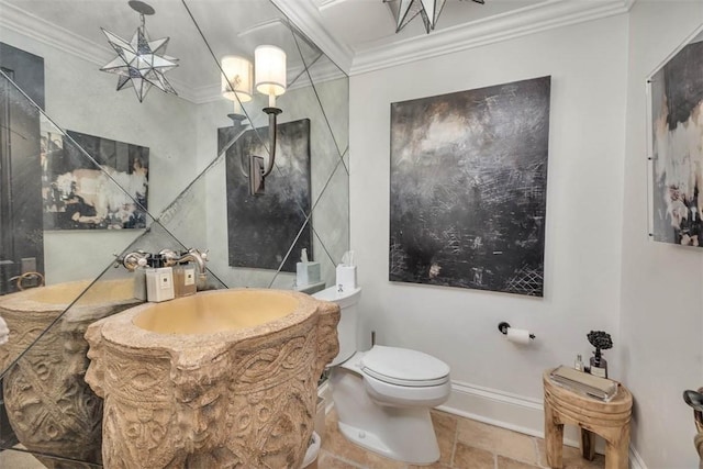 bathroom with toilet, ornamental molding, and sink