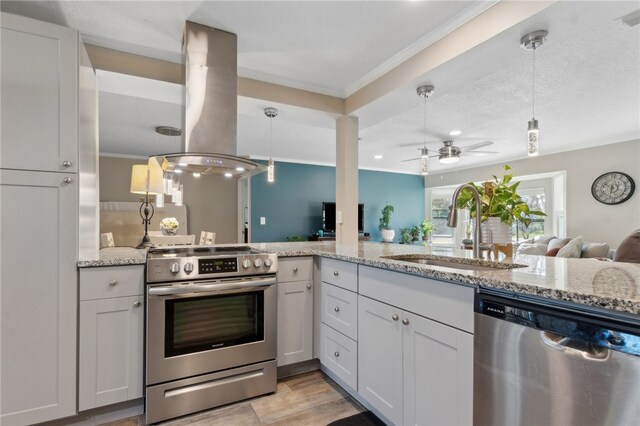 15 Merganser Way, Woodbine, GA 31569 - kitchen featuring light stone counters, island exhaust hood, a sink, hanging light fixtures, and appliances with stainless steel finishes