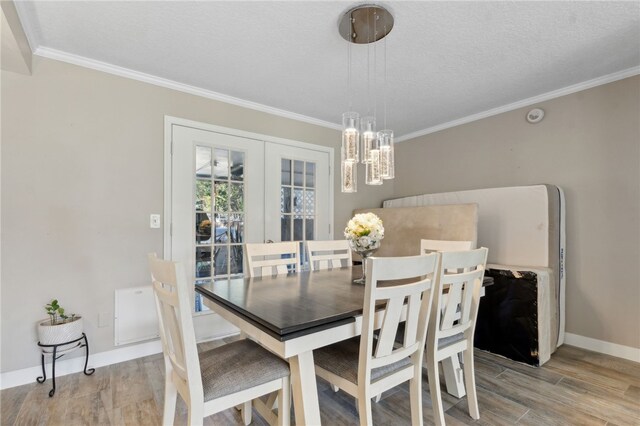 15 Merganser Way, Woodbine, GA 31569 - dining area with light wood-style flooring, an inviting chandelier, crown molding, and baseboards