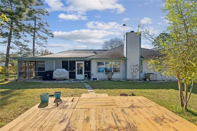 15 Merganser Way, Woodbine, GA 31569 - rear view of property featuring a lawn, central AC, a chimney, and a sunroom