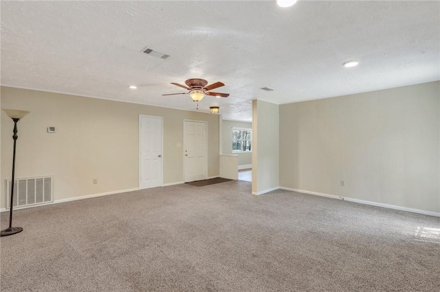 empty room with visible vents, carpet flooring, baseboards, and ceiling fan