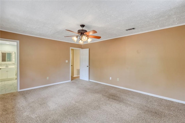 unfurnished room featuring a ceiling fan, carpet flooring, and crown molding