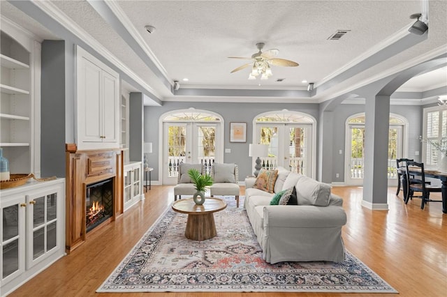 142 Montrose, Saint Simons Island, GA 31522 - living area featuring arched walkways, a ceiling fan, french doors, light wood-style floors, and ornamental molding