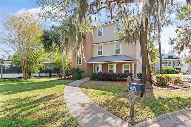 142 Montrose, Saint Simons Island, GA 31522 - view of front facade with stucco siding, metal roof, and a porch