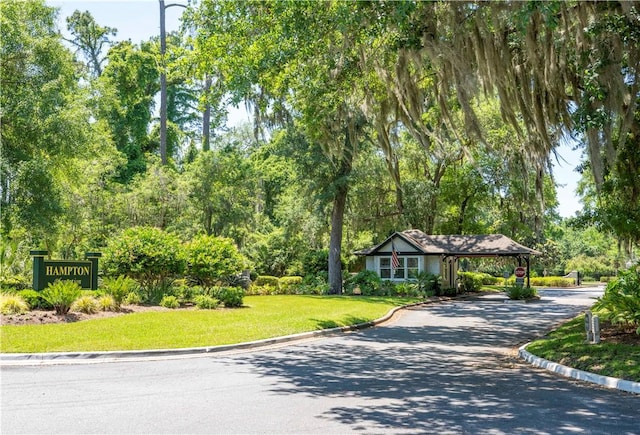 142 Montrose, Saint Simons Island, GA 31522 - view of property's community featuring asphalt driveway, a lawn, and an attached carport