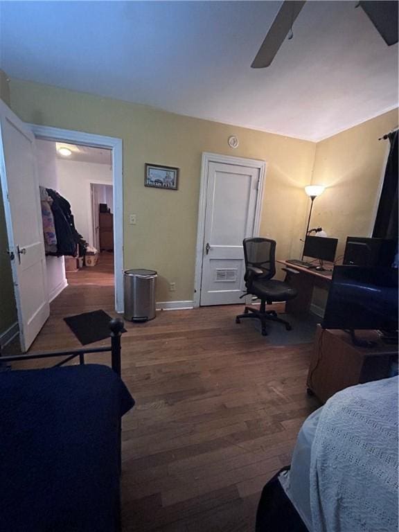 1401 Carswell Ave, Waycross, GA 31501 - bedroom featuring wood finished floors, a ceiling fan, a desk, and baseboards