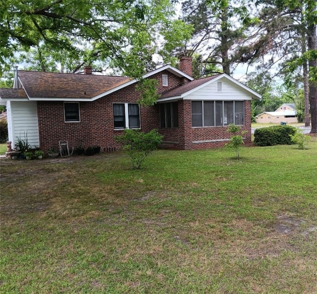 1401 Carswell Ave, Waycross, GA 31501 - ranch-style home with a chimney, a sunroom, brick siding, and a front yard