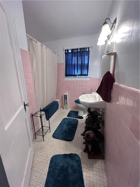 1401 Carswell Ave, Waycross, GA 31501 - bathroom with tile walls, a shower with shower curtain, tile patterned floors, wainscoting, and a sink